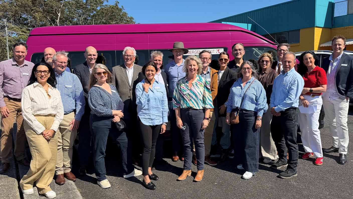 Uniting leadership team standing outside next to a Uniting bus.
