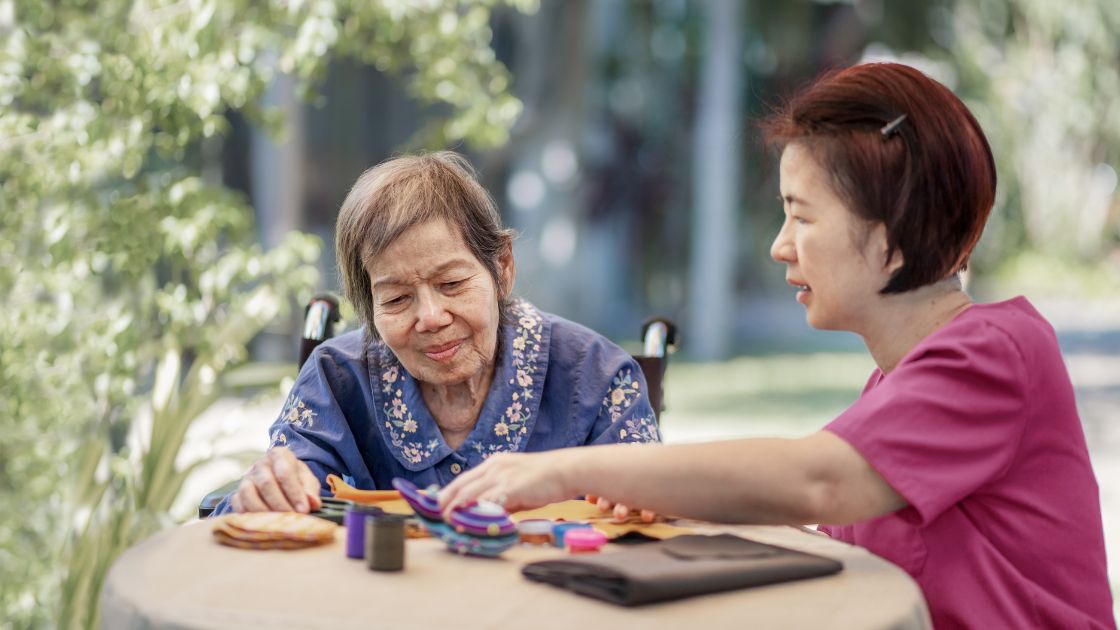 Uniting Support Worker and senior playing Majong