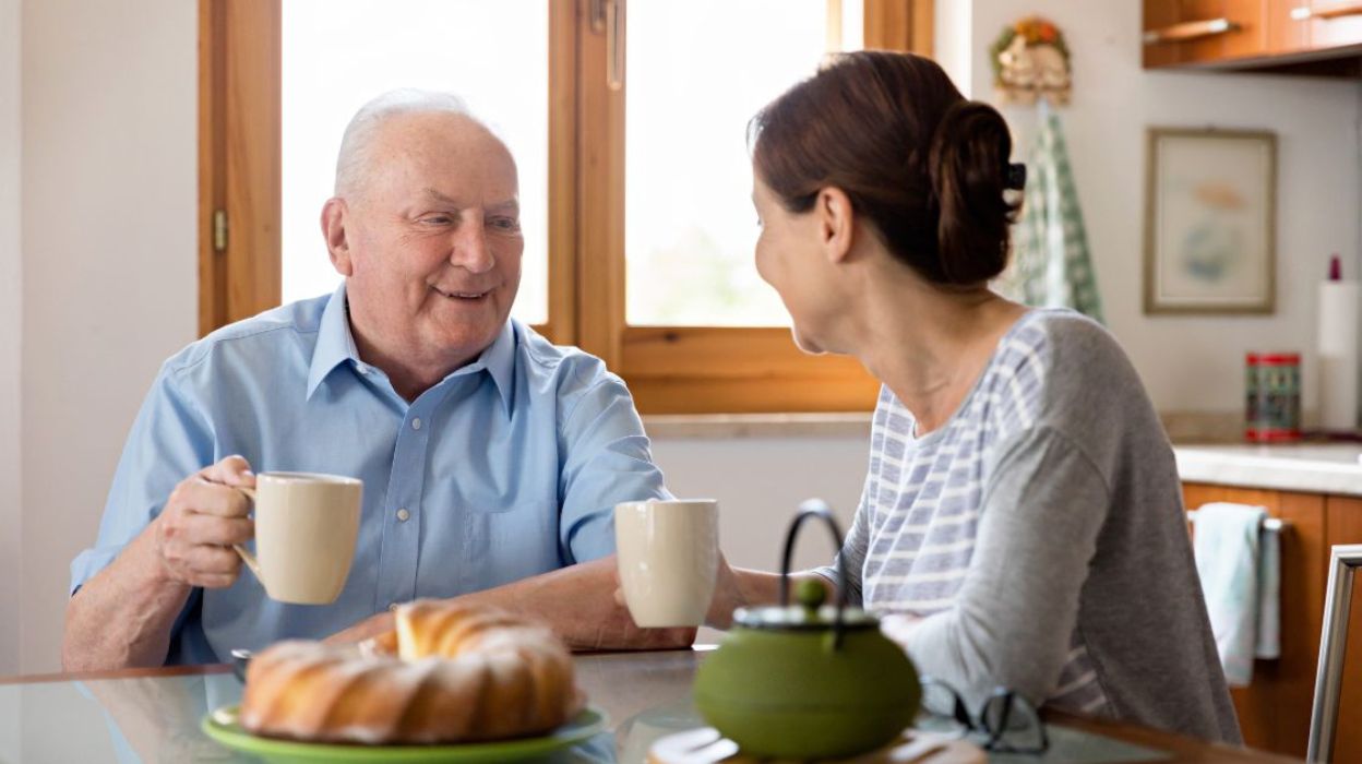 Older man and a woman having tea and talking