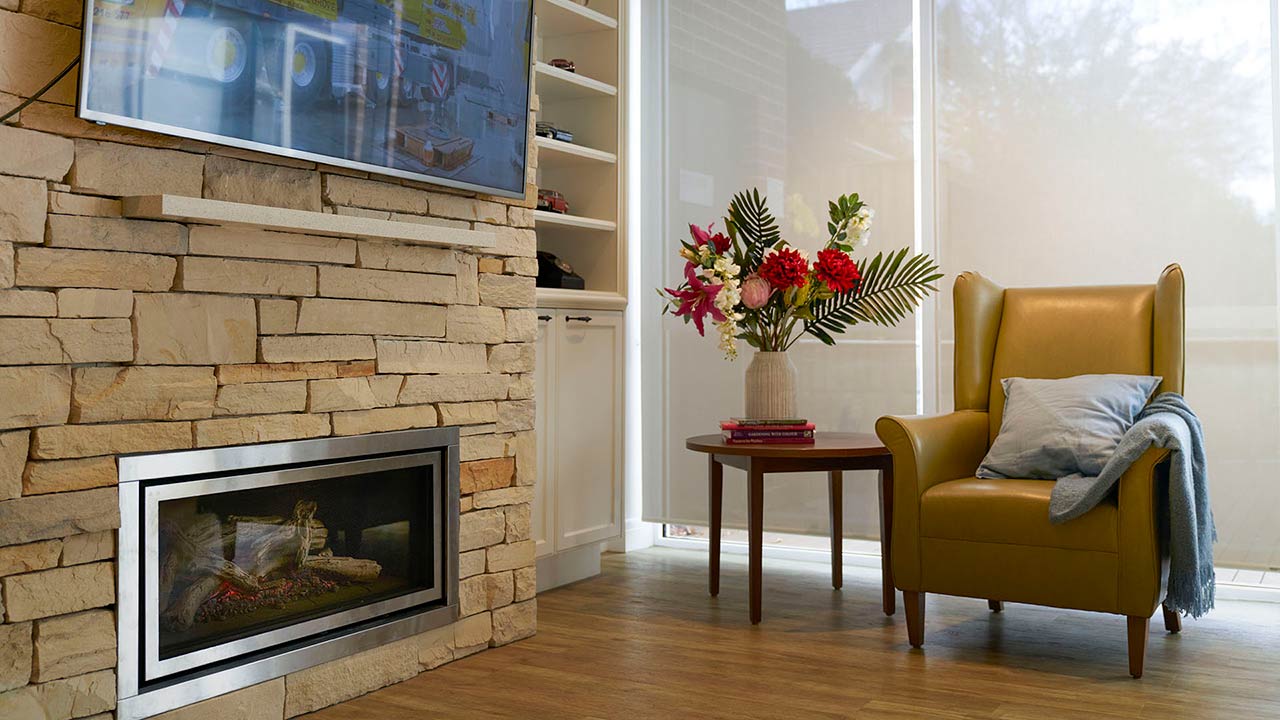 Cosy lounge with fireplace where residents can spend time together, join in with activities, watch movies, or listen to music 