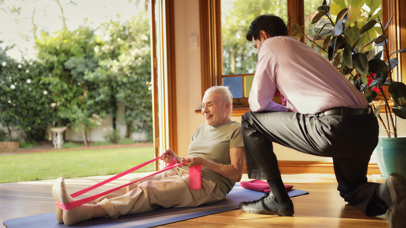 Uniting staff with an elderly woman using an exercise band. Uniting staff with an elderly woman using an exercise band.
