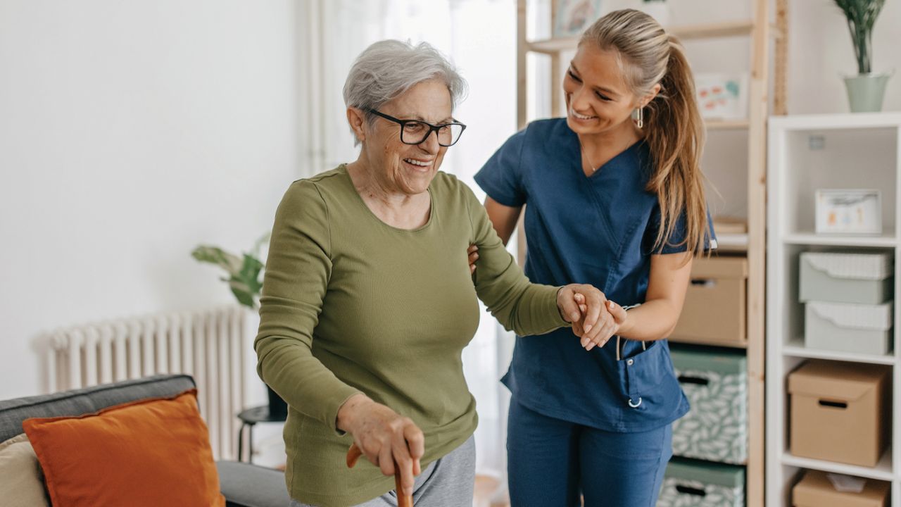 Uniting nurse helping senior woman with walking stick