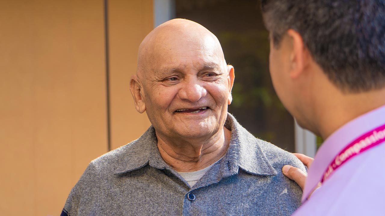 An older man talking to a physiotherapist