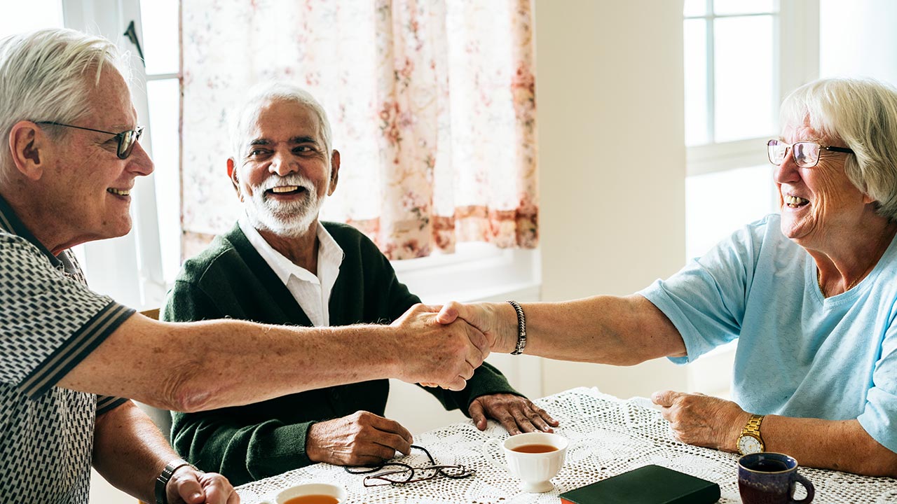 A group of older people chatting over coffee