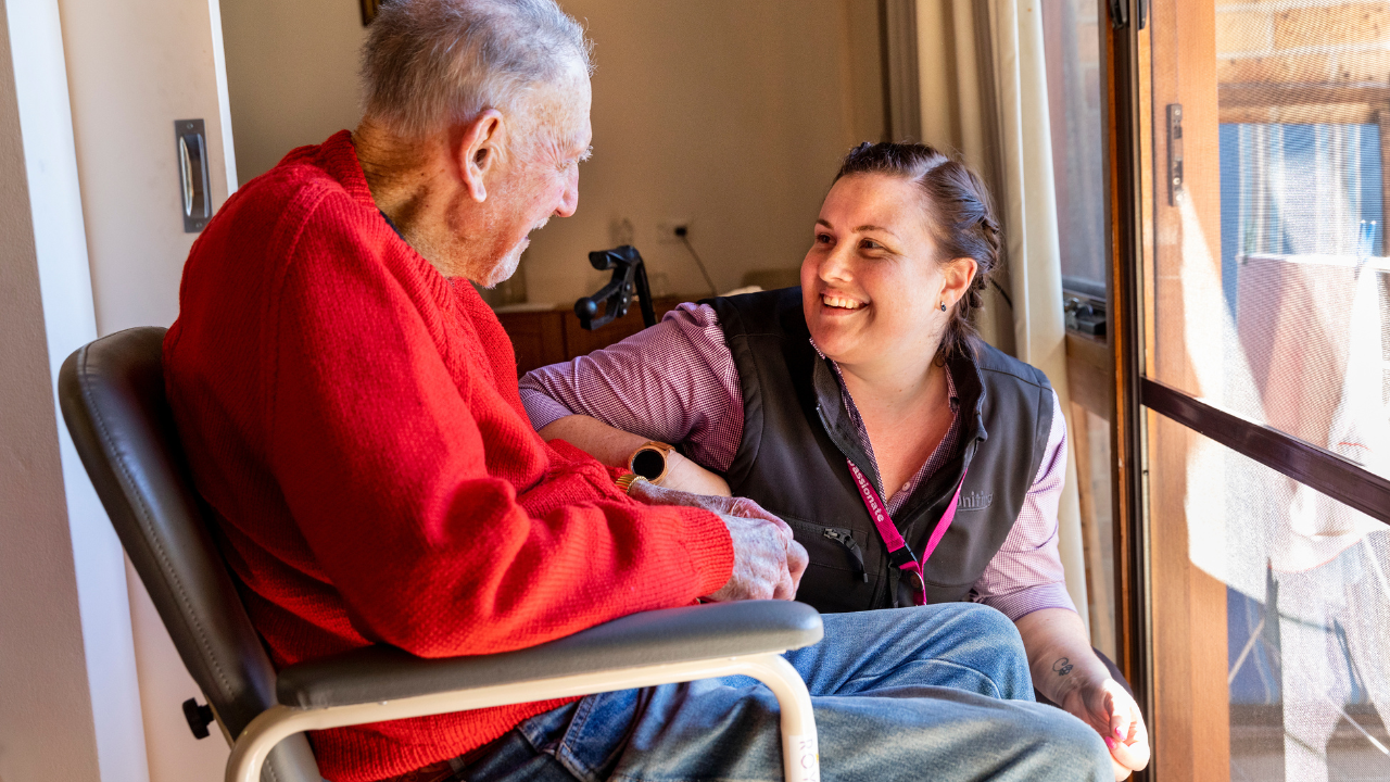 Uniting staff member talking to senior man in chair