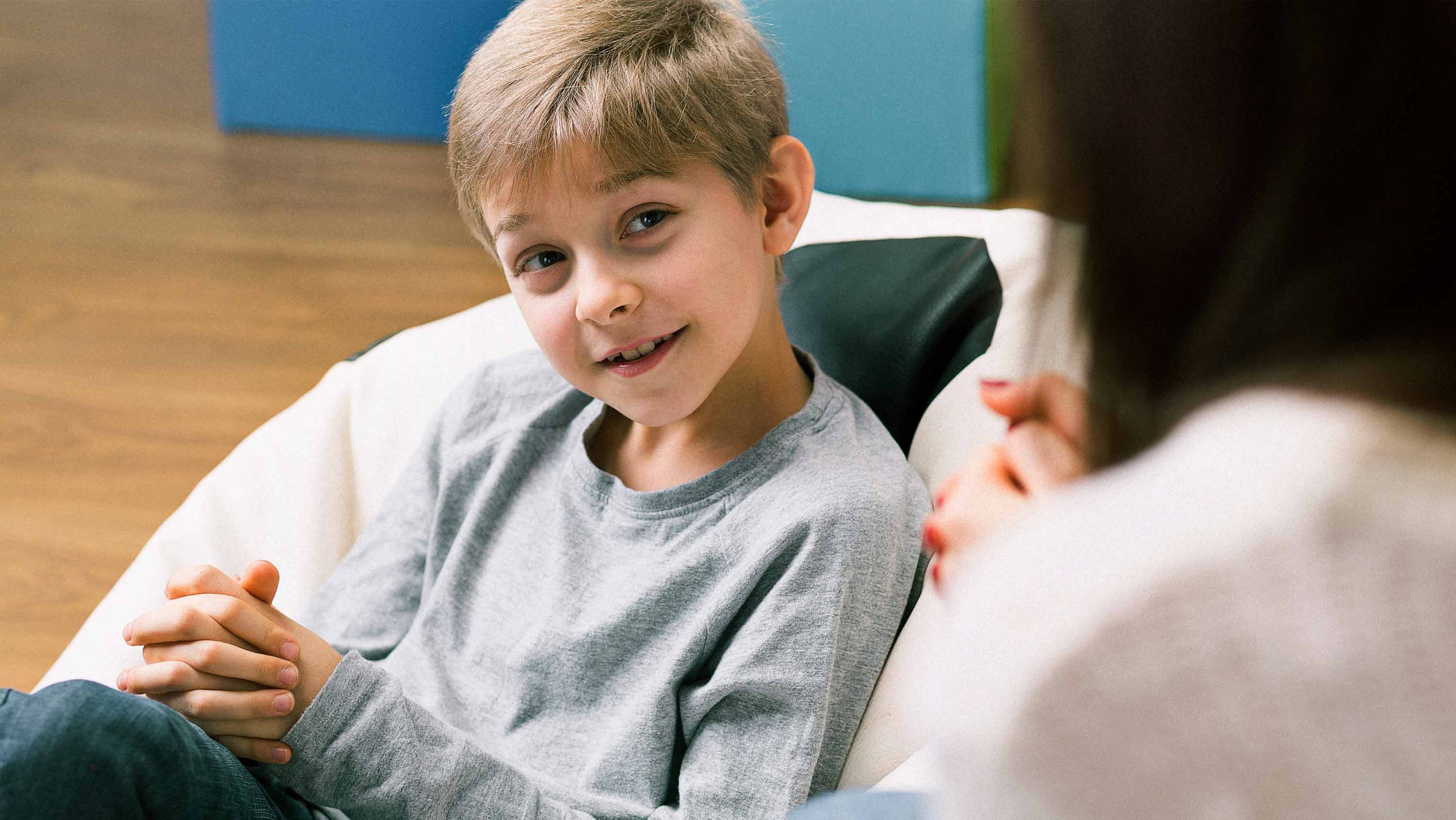 A young child sits and talks confidently with a counsellor