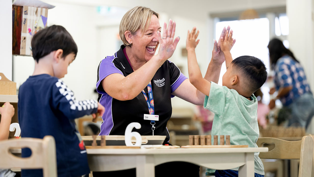 Educator giving child a high 5.