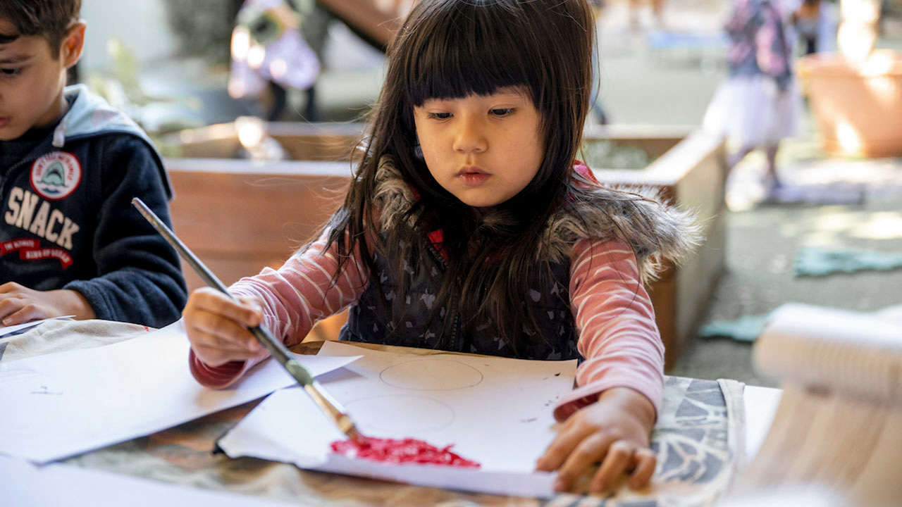 Child painting outside.