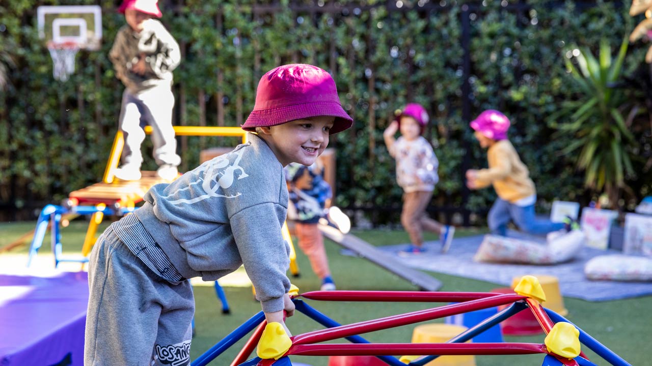 Child climbing on outdoor play equipment.