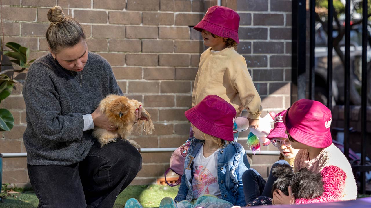 Educator and children holding chickens.