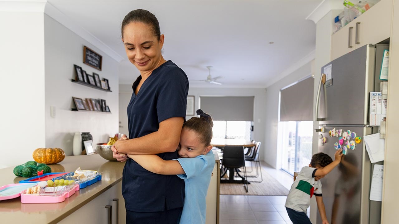 A child hugging a woman in a kitchen A child hugging a woman in a kitchen