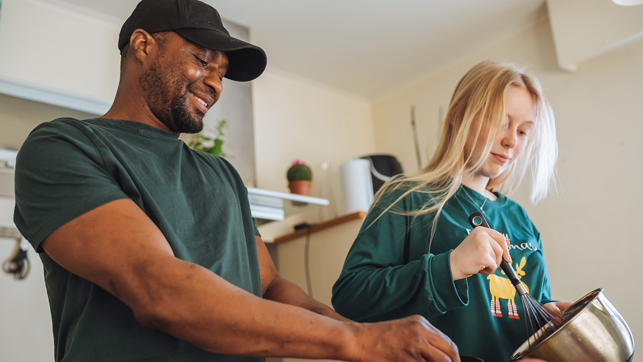 Man and girl cooking in a kitchen together