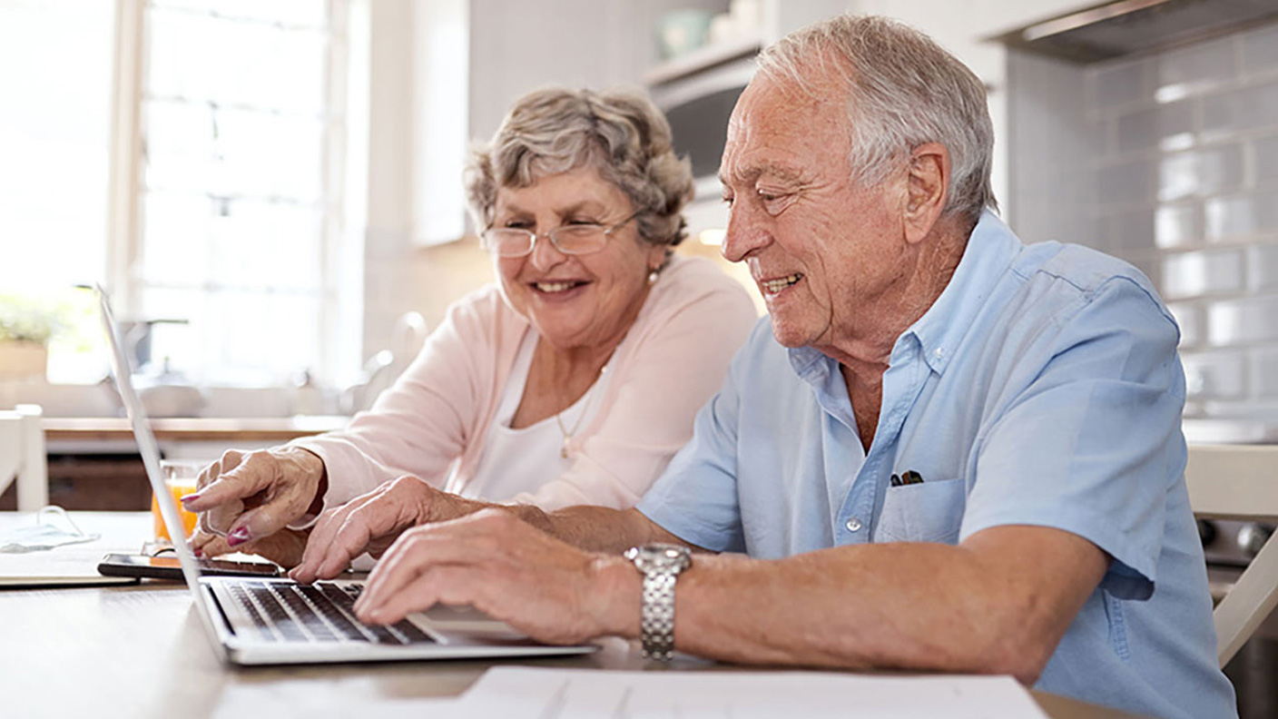 Happy senior couple working on a laptop