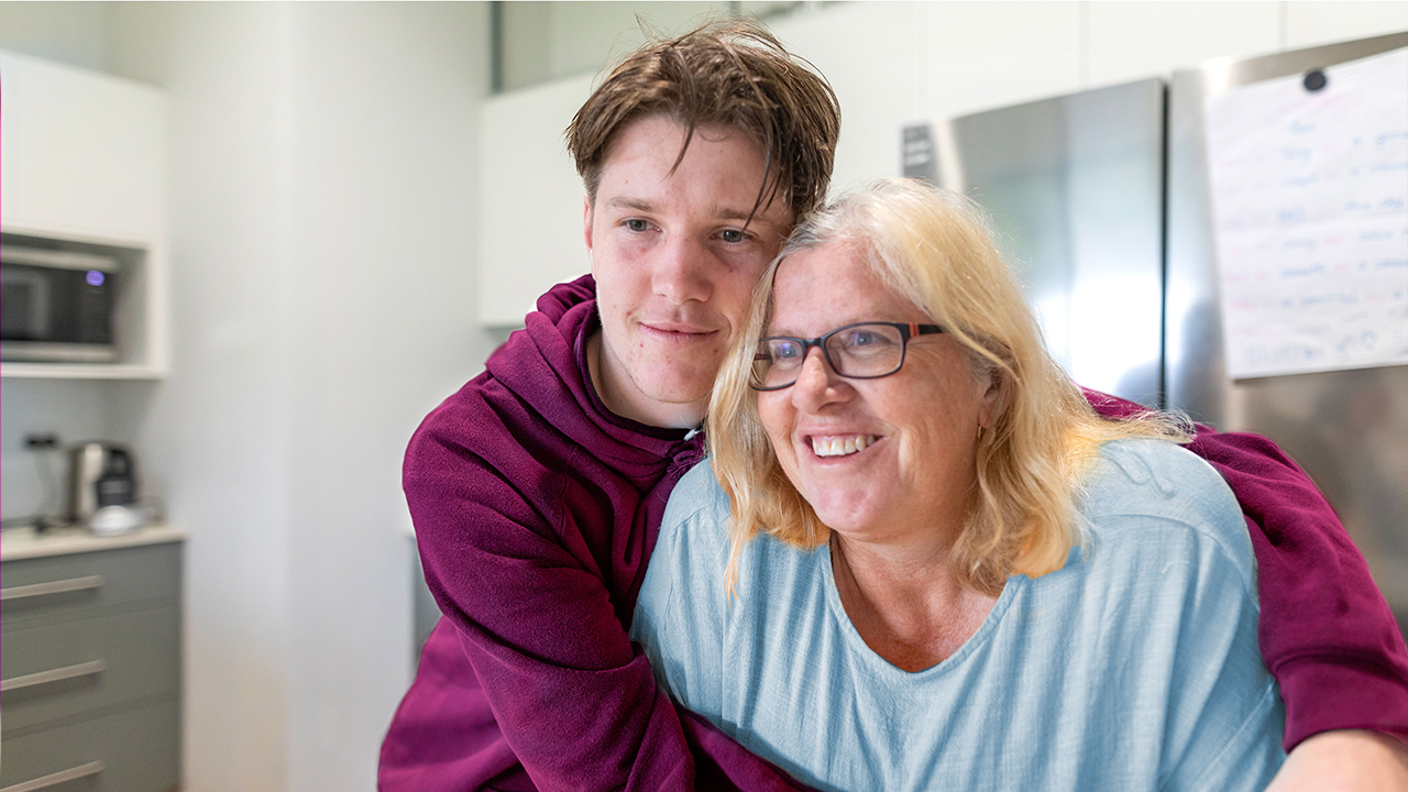 Young man hugging a smiling older woman Young man hugging a smiling older woman