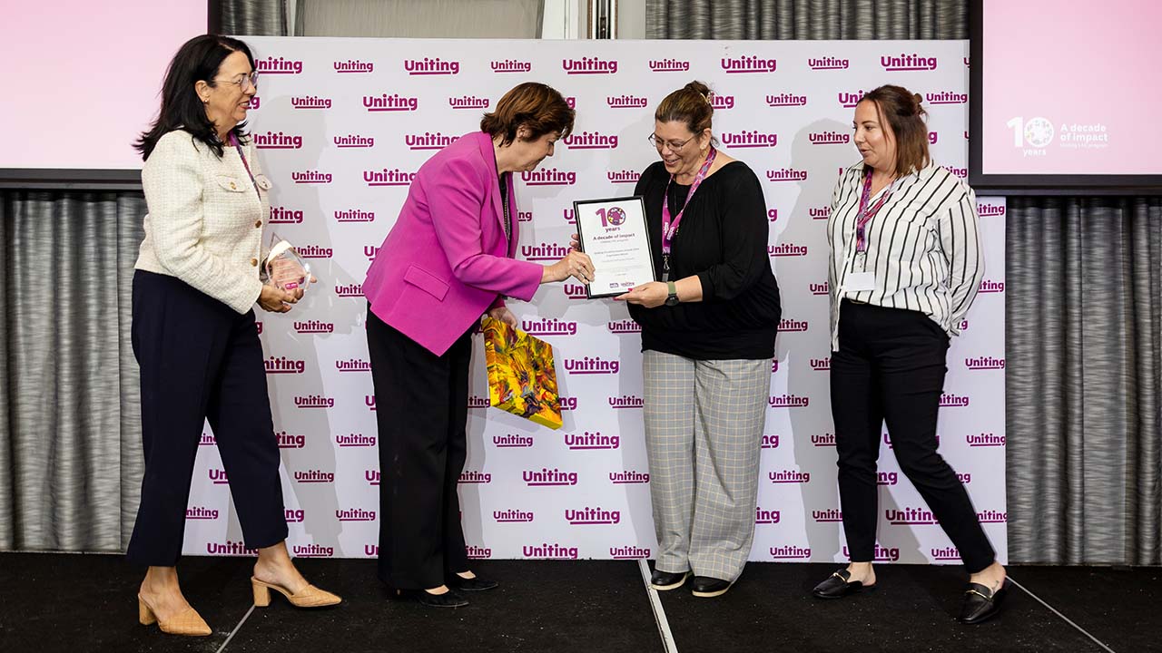 Tracey Burton presenting a framed certificate and artwork to 2 representatives from Goulburn Inclusion Forum.