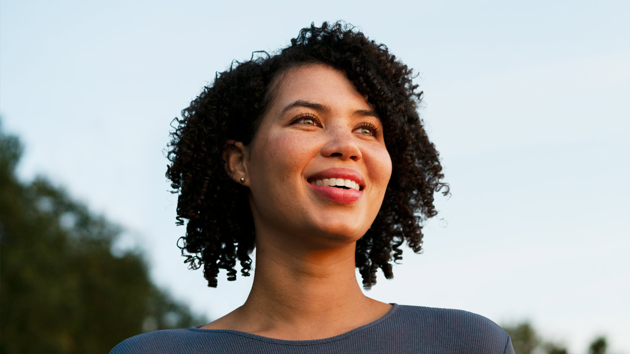 A young woman looks confidently at the camera.